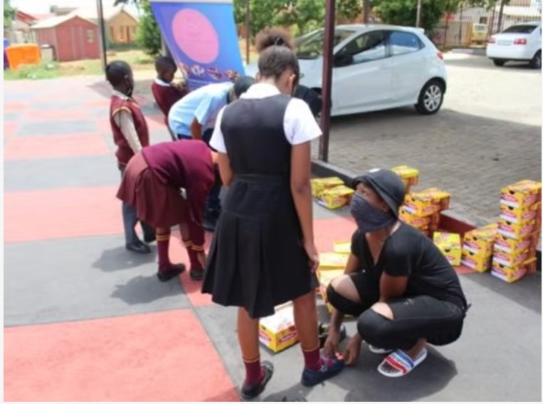 Learners receiving new school shoes and supplies at a Phehello school drive